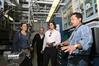 Image of <p>Sandia’s Daniel Soh, right, offers an overview of the continuous variable quantum key distribution (CV-QKD) laboratory for the Department of Homeland Security’s Mike Pozmantier (center, white shirt). Pozmantier, program manager for DHS’s Transition to Practice program in the department’s Cyber Security Division, visited Sandia/California recently to observe various cybersecurity projects at the lab and discuss Sandia’s test and evaluation role in TTP.      (Photo by Dino Vournas)</p>