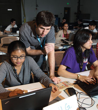 Cyber Technologies Academy teacher Craig Shannon (8966), a Sandia cybersecurity researcher, checks a student’s progress on an exercise. Academy classes offer a mix of lectures and hands-on learning.