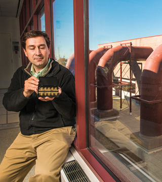 Murat Okandan (1719) holds one of the microscale actuators that could lead to better understanding of brain function, which could help with prevention, diagnostic, and treatment techniques for brain disorders.	(Photo by Randy Montoya)