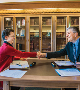 Julia Phillips, Sandia Acting Div. 7000 VP and chief technology officer, and UNM Provost Chaouki Abdallah shake hands after signing the Inter-Institutional Visitors Agreement allowing closer research collaboration. (Photo by Randy Montoya)