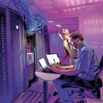 Sandia computer scientists Ron Minnich (foreground) and Don Rudish have successfully run more than a million Linux kernels as virtual machines, an achievement that will allow cyber security researchers to more effectively observe behavior found in malicious botnets. They utilized Sandia's powerful Thunderbird supercomputing cluster for the demonstration. (Photo by Randy Wong)