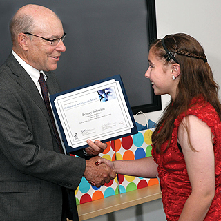 Image of WELL DONE! - Div. 8000 VP Rick Stulen congratulates Britney Johnston, winner of the Outstanding Achievement in Science Award for Manteca's East Union High School. (Photo by Dino Vournas) <a href="/news/publications/labnews/archive/_assets/images/12-15-06/swc.jpg">View large image</a>. <br/>