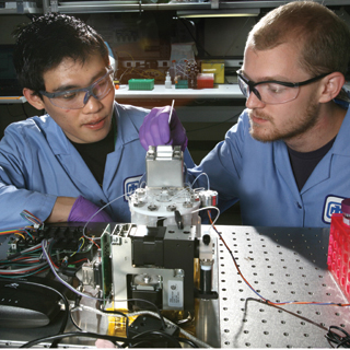 Image of Summer  interns Harrison Edwards and Daniel Lee (both 8125) work with the Battlefield  DNA Analysis amplification module. (Photo  by Dino Vournas) <a href="/news/publications/labnews/archive/_assets/images/12-24-08/dna1260.jpg">View large image</a>.