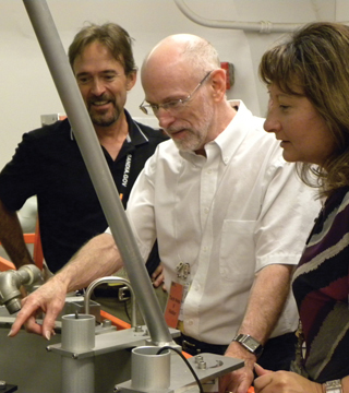 Image of <p>CRITICAL INFORMATION — Bob Busch, center, a University of New Mexico nuclear engineering professor, goes over features of the Sandia Pulsed Reactor/Critical Experiments (SPR/CX), with Labs contractors Chris Hall (4126) and Cassandra Wilson (1385). Chris and Cassandra were students in a course Busch taught at Sandia over the summer that gave nuclear engineering training to Tech Area V staff who didn’t have that background. (Photo by Shawn Howry)</p>