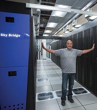 COOL GUY — Dave Martinez (9324) shows off the new Sky Bridge installation. Dave is the Facilities project lead and is responsible for making sure the supercomputer gets power and cooling. He has been a key innovator for Sandia’s corporate data centers and has enabled us the Labs to deploy new technologies in power and cooling in machines such as Sky Bridge.