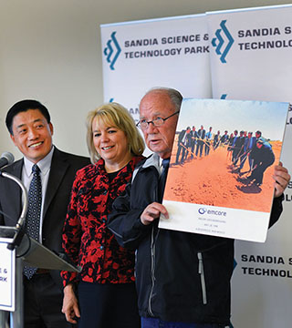 BUSINESS LEGACY — Sherman McCorkle, right, shows a photo of the May 28, 1998, groundbreaking for Emcore Corp., one of the founding tenants in the Sandia Science & Technology Park. Emcore’s longtime president and CEO Hong Hou, a former Sandian who is stepping down following the sale of the company’s photovoltaics division in the research park, looks on along with Jackie Kerby Moore, the park’s executive director and manager of Technology and Economic Development Dept. 1933. McCorkle, former president of Technology Ventures Corp., was instrumental in establishing the park and is now chairman of the board of the SS&TP Development Corp. (Photo by Randy Montoya)