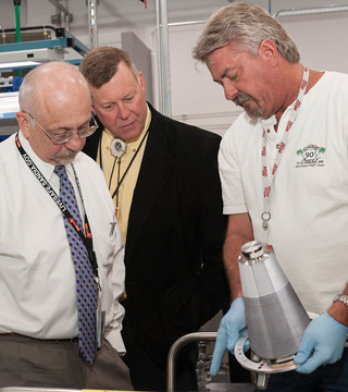 KANSAS CITY WORK — Sandia President and Laboratories Director Paul Hommert, left, and Geoffrey Beausoleil, manager of the NNSA Sandia Field Office, discuss the complexities of a weapon assembly with expert welder Tim Ward during their tour of the National Security Campus at Kansas City on June 24.	(Photo courtesy of the Kansas City Plant)