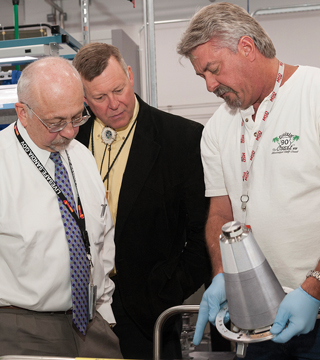 KANSAS CITY WORK — Sandia President and Laboratories Director Paul Hommert, left, and Geoffrey Beausoleil, manager of the NNSA Sandia Field Office, discuss the complexities of a weapon assembly with expert welder Tim Ward during their tour of the National Security Campus at Kansas City on June 24. (Photo courtesy of the Kansas City Plant)