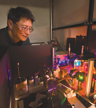 Jeff Tsao (1120) looks over a set-up used to test diode lasers as an aternative to LED lighting. (Photo by Randy Montoya)