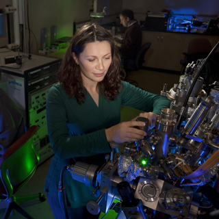 Sandia researchers Elena Starodub, Kevin McCarty (far left) and Norm Bartelt (far right) around the Low Energy Electron Microscope used to study graphene growth.	(Photo by Randy Wong)