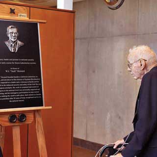 RETIRED SANDIA EXECUTIVE VP Jack Howard ponders the plaque that will be displayed in his honor in Sandias Bldg. 800. Jack, who launched Sandias California site in 1956 and was an early champion of improved use control and safety measures in nuclear weapons, is the third member of Sandias Hall of Fame, joining Sandia pioneers Glenn Fowler and Bob Henderson.	(Photo by Randy Montoya)