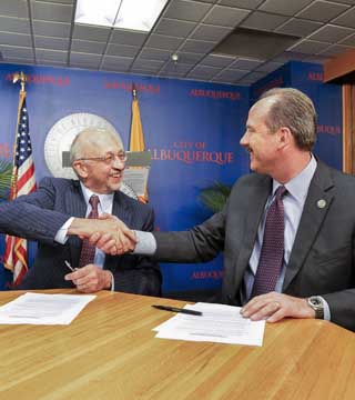 Sandia Labs Director Paul Hommert and Albuquerque Mayor Richard Berry shake on a new Memorandum of Understanding between the Labs and the city. “We have a lot of things to work on, a broad scope of issues,” Berry said at the MOU signing.     (Photo by Randy Montoya)