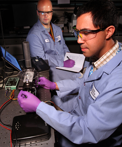 Ulrich Schaff (8621) prepares the “lab-on-a-disk” radiation biodosimeter to run immunoassay experiments while Greg Sommer (8621) monitors the assay control and records data. The two hope to begin validating their data against established benchtop methods this summer. (Photo by Dino Vournas)