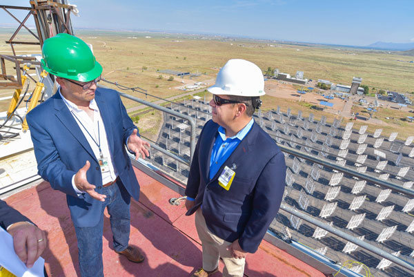 DON’T LOOK DOWN — Ken Armijo, lead organizer for the solar celebrations, talks to U.S. Rep. Ben Ray Lujan on top of the solar tower. The tower stands 200 feet tall and overlooks a field of 212 heliostats.