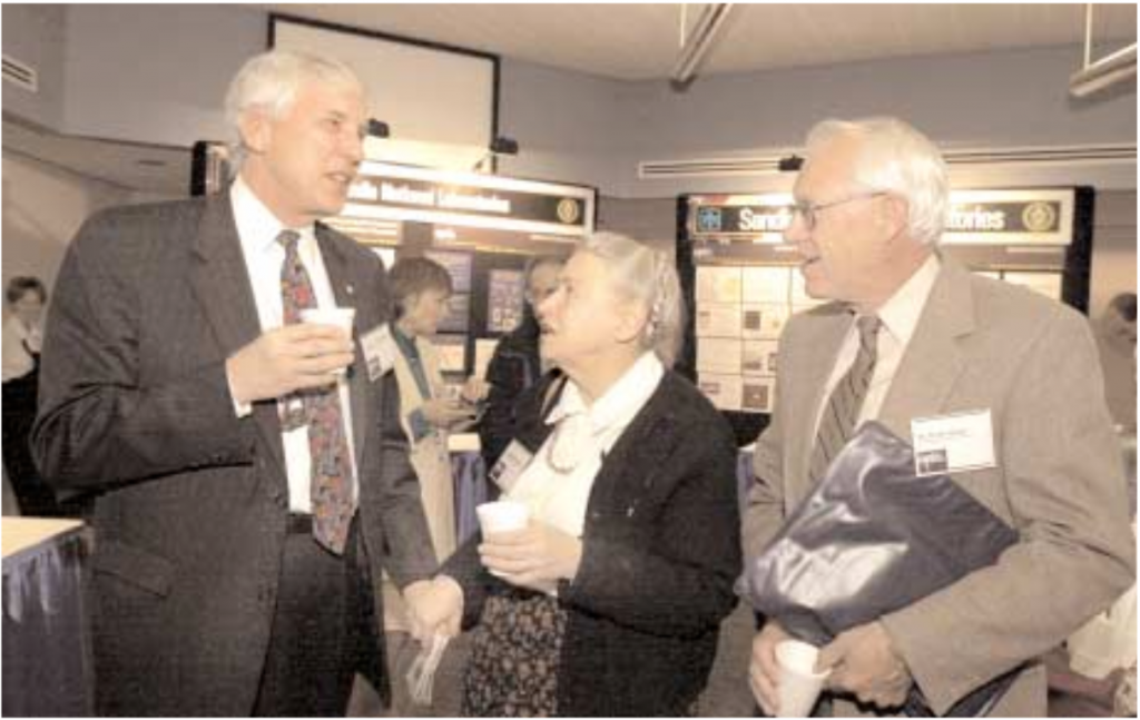 NOW LISTEN HERE — DOE’s chief scientist, Dr. Mildred Dresselhaus, makes an emphatic point to Labs President andDirector C. Paul Robinson during the Dec. 14 Sandia Science Day. Dresselhaus accompanied National Nuclear SecurityAdministration chief Gen. John Gordon to Sandia to promote the importance of “science with the mission in mind” atthe nation’s nuclear weapons labs. At right is former Sandia Executive VP Orval Jones.