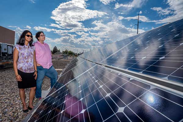 Image of Sandia researchers examine solar panels