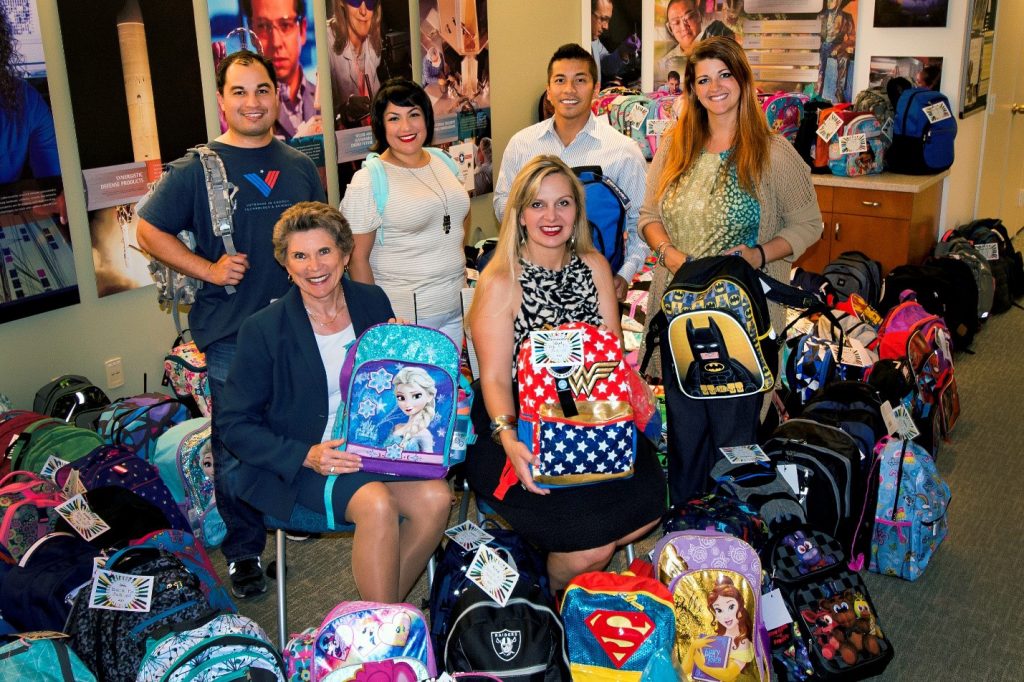 SANDIANS pose amidst an overflow of donations. Bottom, left to right: Associate Labs Director Dori Ellis and Rachel Sowell (8000). Top, left to right: Adrian Valenzuela, Lawrence Livermore National Lab, Sarah Ann Flores (8524), Brian Abelgas (8146), and Angela Tallman, LLNL.