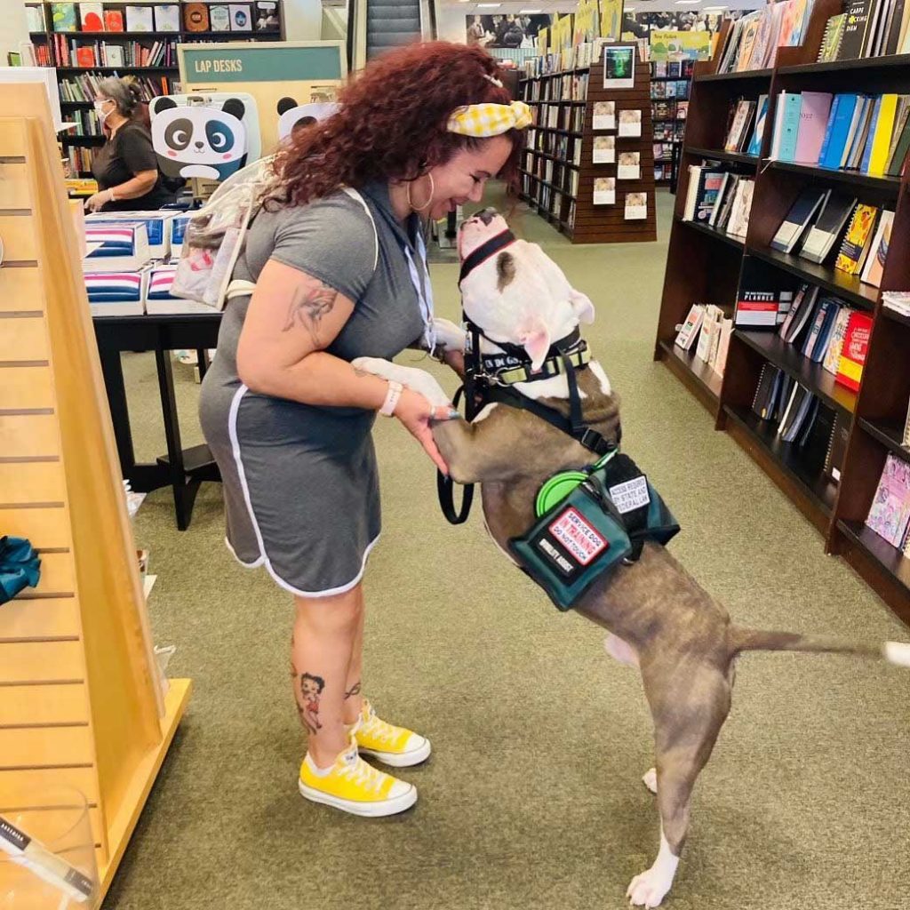 SHOPPING SPREE — A veteran and her dog Whiskey, a graduate of Paws and Stripes, take a trip to the bookstore. (Photo courtesy of Paws and Stripes)
