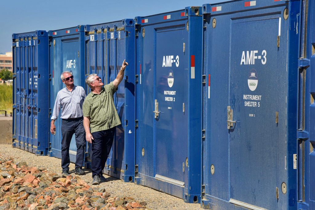 FROM ALASKA, WITH CARE — Fred Helsel, right, a Sandia systems engineer, points out a feature of a shelter that had been stationed in Oliktok Point, Alaska to Mark Ivey, a senior engineer who has been involved in the Atmospheric Radiation Measurement user facility for nearly three decades. After eight great years of observations and research, a Sandia-operated atmospheric measurement facility moved from Oliktok Point. (Photo by Randy Montoya)