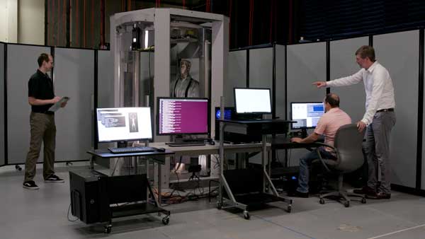 NEXT STEP, BODY SCANNER UPGRADES — Researchers, including Pacific Northwest National Laboratory’s R. Trevor Clark, left, and Stratovan President and CTO David Wiley, far right, work on next phases of OTAP. The team’s testing focus has moved beyond carry-on bags. “We’re branching out into helping not just computed tomography – X-ray – algorithm developers but body scanner development,” Ed Jimenez said. (Photo by Eric Francavilla, Pacific Northwest National Laboratory)