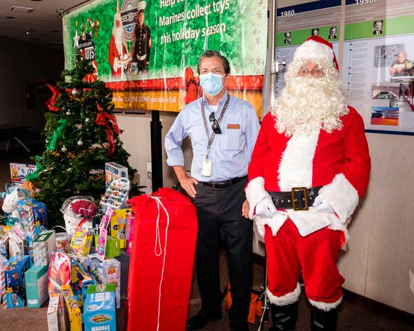 TOYS FOR TOTS — Dennis Baker, leader of Sandia/California’s Toys for Tots campaign, poses with Santa Claus during the donation event on Dec. 2. (Photo by Randy Wong)
