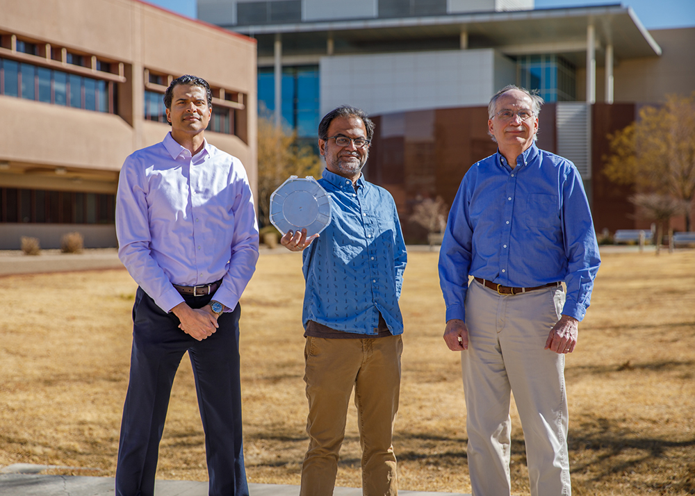 PRECISELY — Sandia’s Conrad James, left, Shashank Misra, center, and Paul Sharps present the first silicon wafer with circuits that combine devices made using atomic precision advanced manufacturing with industry-standard complimentary metal-oxide semiconductors. The wafer was produced at Sandia’s Microsystems Engineering, Science and Applications Complex. (Photo by Bret Latter)