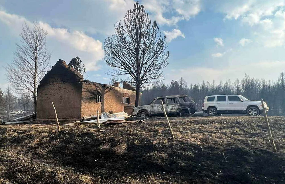 Image of A home and car is damaged due to New Mexico wildfires