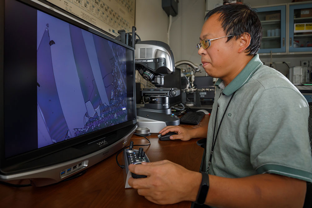 Image of Researcher Guangpin Xu employs digital optical microscope