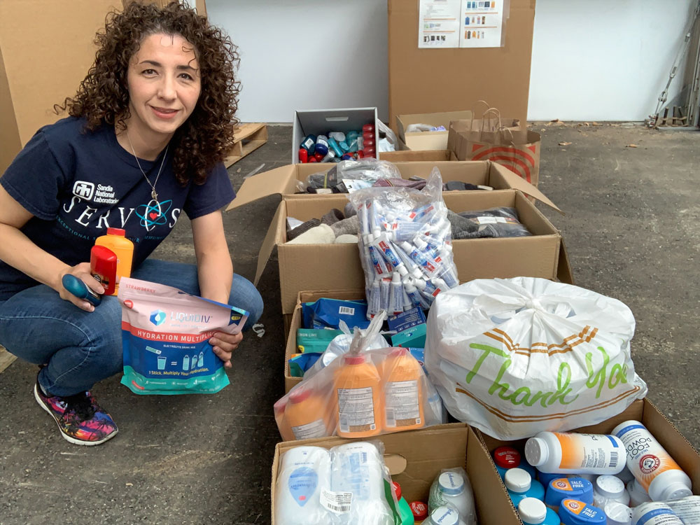 Image of Roberta Rivera and supplies collected for firefighters during Together We Rise