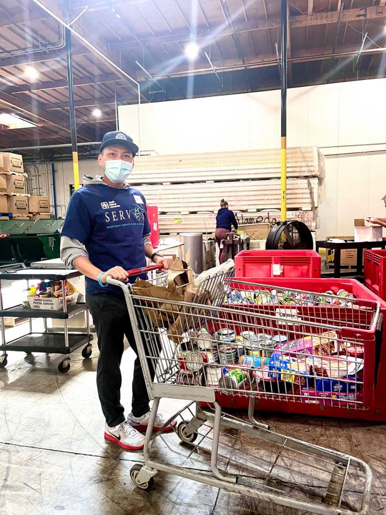 FOOD SERVICE — Project manager Brian Duong carts away food items that are ready to be distributed to local food banks by Alameda County Community Food Bank.