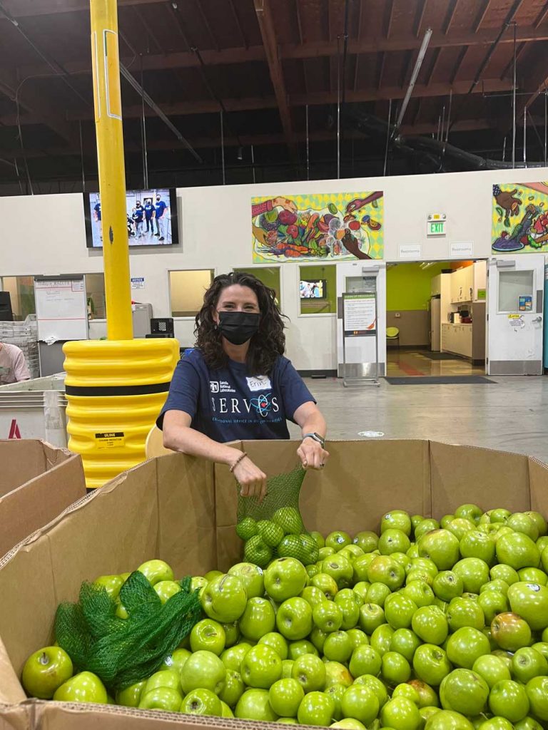 PICKED WITH CARE — Talent acquisition specialist Erin Chandler sorts and packages fresh apples at Alameda County Community Food Bank.
