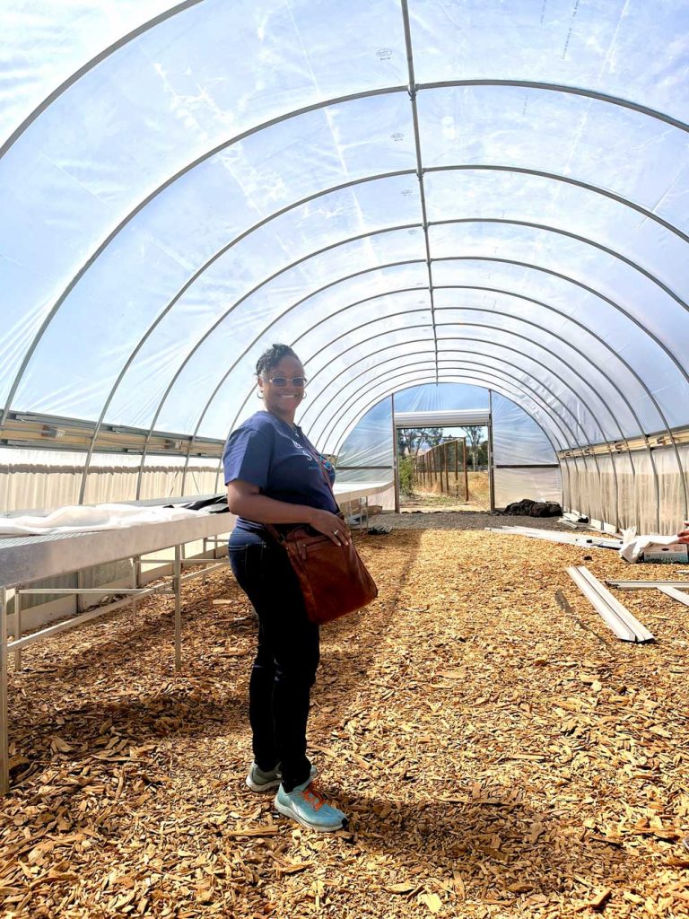 READY FOR PLANTING — Michelle Walker-Wade visits a hoop house, funded by Sandia’s corporate contribution donations to help extend the growing season at Fertile GroundWorks.