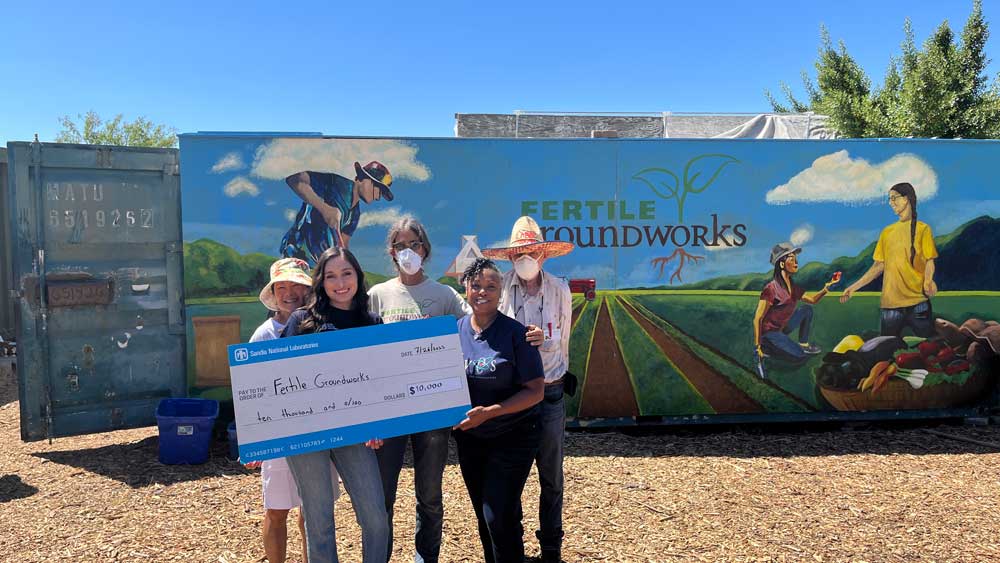 HELPING THEM GROW — Sandia/California Community Involvement team members Tatiana Del Cid, second from left, and Michelle Walker-Wade, second from right, present a $10,000 check to the Fertile GroundWorks leadership team on July 26. (Photo courtesy of Fertile GroundWorks)