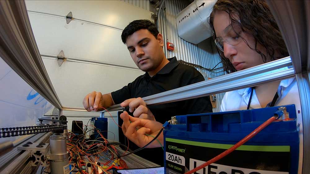 ROBOTIC WORK — Michael Vázquez Nieves, left, and Alanis Colón González, Sandia interns from the Consortium of Hybrid Resilient Energy Systems, work together to build a photovoltaic robot. (Photo by Vince Gasparich)