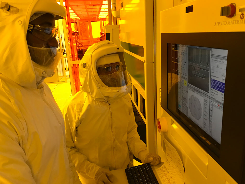 LIGHT BRIGHT — Bishnu Khanal, right, and Kel Okoro examine the quality of microelectronic devices on an electron microscope that is patterned using advanced optical lithography. (Photo by Philip Shapiro)