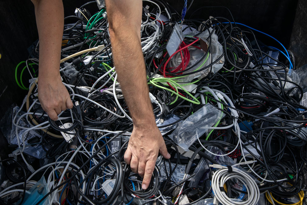 Image of STRIKING A “CORD” — Representatives from schools pick through a box of cords during Sandia’s Annual K-12 Computer Donation event