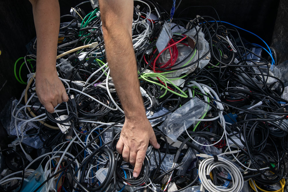 STRIKING A “CORD” — Representatives from schools pick through a box of cords during Sandia’s Annual K-12 Computer Donation event.