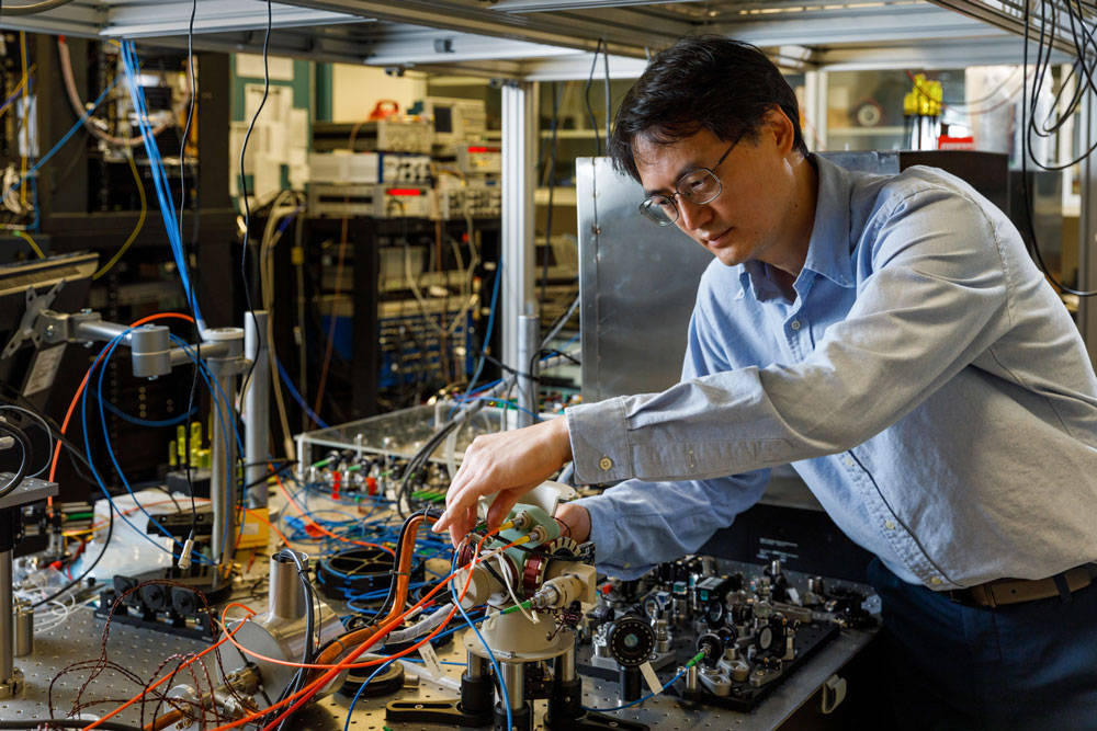 TOUGH ENOUGH? — Sandia atomic physicist Jongmin Lee examines the sensor head of a cold-atom interferometer that could help vehicles stay on course where GPS is unavailable. (Photo by Bret Latter)
