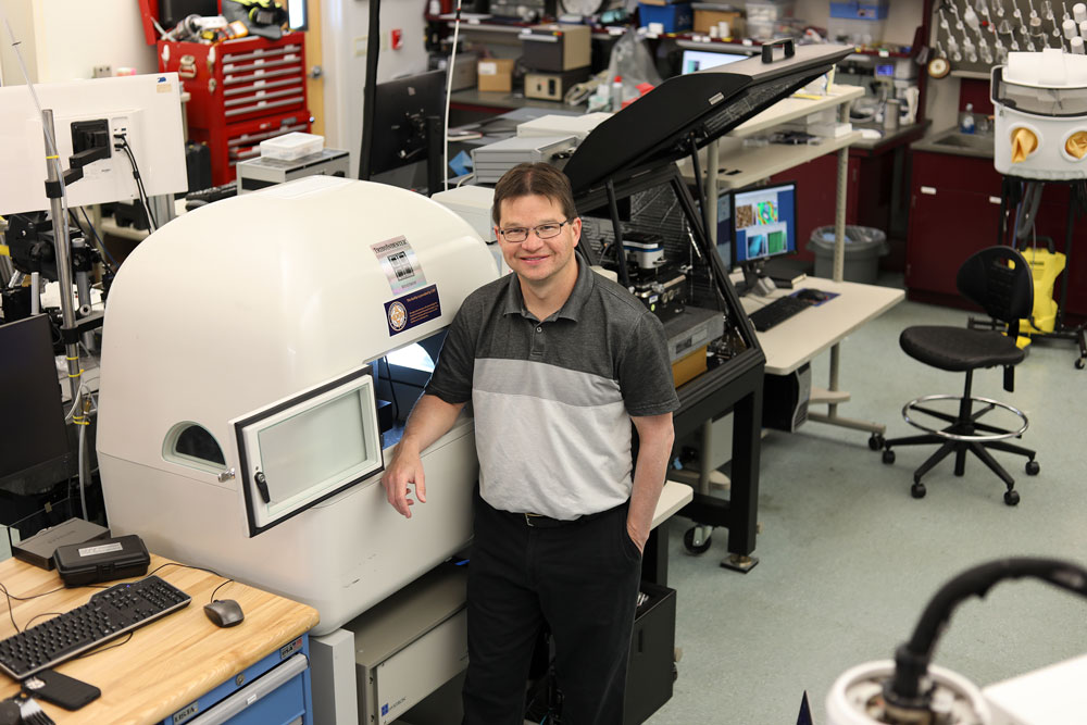 PIT MANEUVERS — Sandia mechanical engineer Frank DelRio works on a nano-indenter to investigate the chemo-mechanical weakening of layered phyllosilicate muscovite mica in liquid environments. (Photo by Lonnie Anderson)