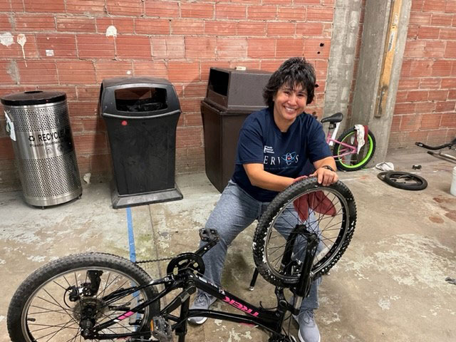 Image of Associate Labs Director Rita Gonzales repairs a bicycle with Free Bikes for Kidz New Mexico