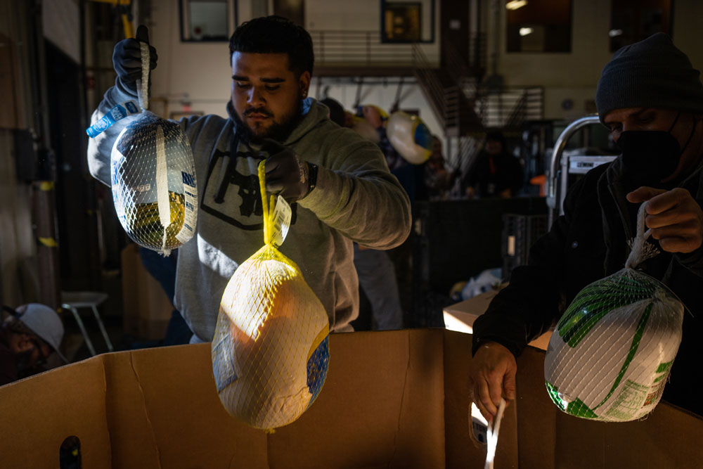 Image of Juan Reyes, left, and Jonathan Lucero unpack frozen turkeys at Roadrunner Food Bank