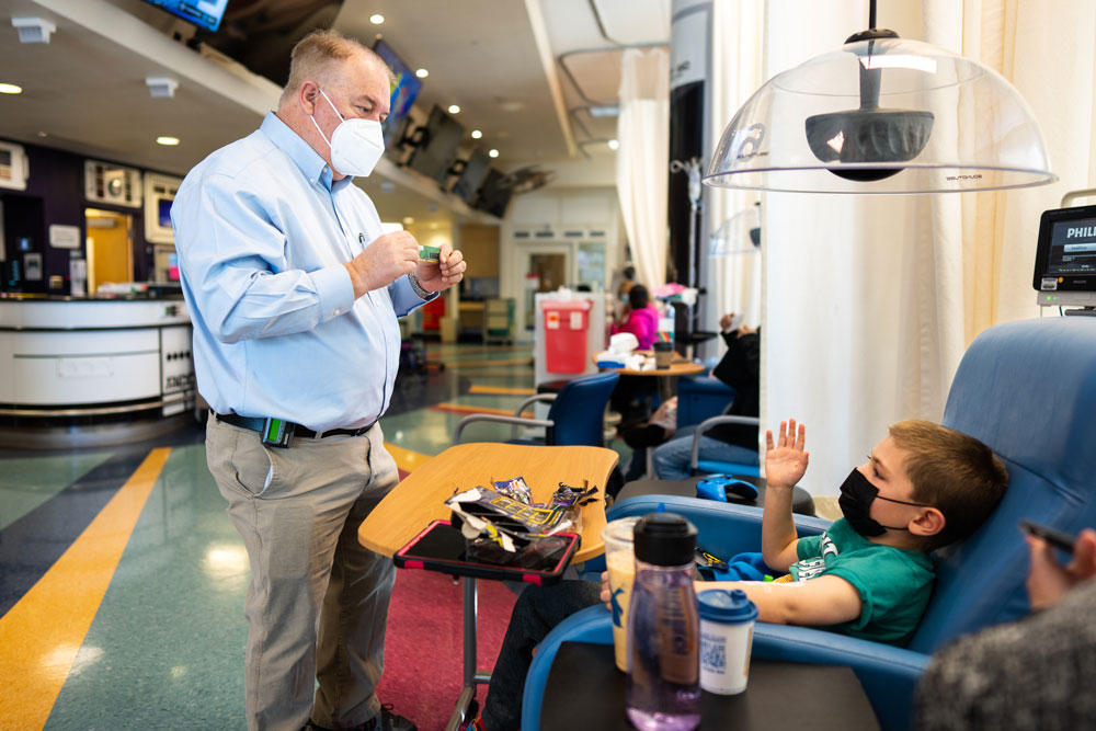 STEM DEMO — Executive Labs Director and Chief Information Officer John Zepper shows a computer chip to Robert Rossiter at the UNM Children’s Hospital Infusion Clinic. (Photo by Craig Fritz)