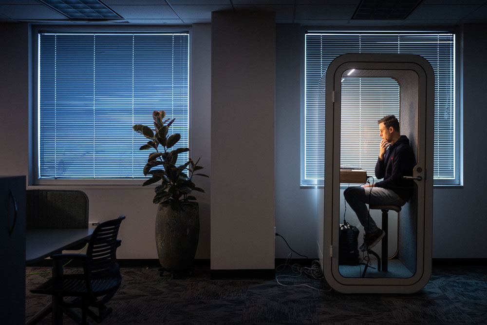 WINNING TOUCHDOWN — Matthew-Ryan Morrell, strategic site planning manager, uses a soundproof booth to participate in a Teams meeting at the collaboration space in IPOC. (Photo by Craig Fritz)