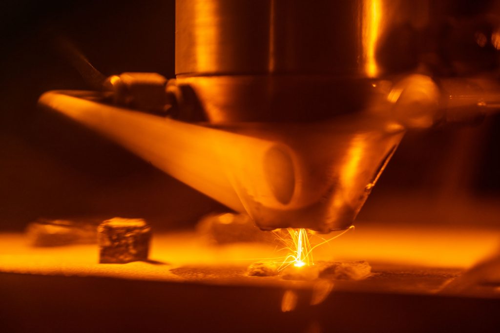 LITTLE SPARKY — 3D-printing technologies like Laser Engineered Net Shaping, shown here, are helping scientists at Sandia rapidly discover, prototype and test new materials. (Photo by Craig Fritz)