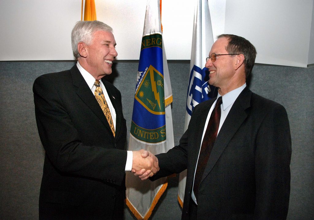 PASSING THE BATON — Paul Robinson, left, congratulates Tom Hunter. During a special staff meeting, Tom was announced as Laboratories president and director. (Photo by Randy Montoya)