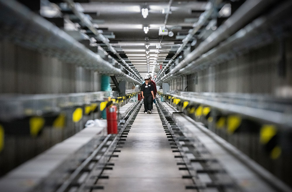 A RARE VISIT — New Mexico high school students from Grants, Gallup and Hiroshi Miyamura high schools walk through the quarter-mile-long tunnel beneath the heliostat field at the National Solar Thermal Test Facility during a STEM tour. (Photo by Craig Fritz)