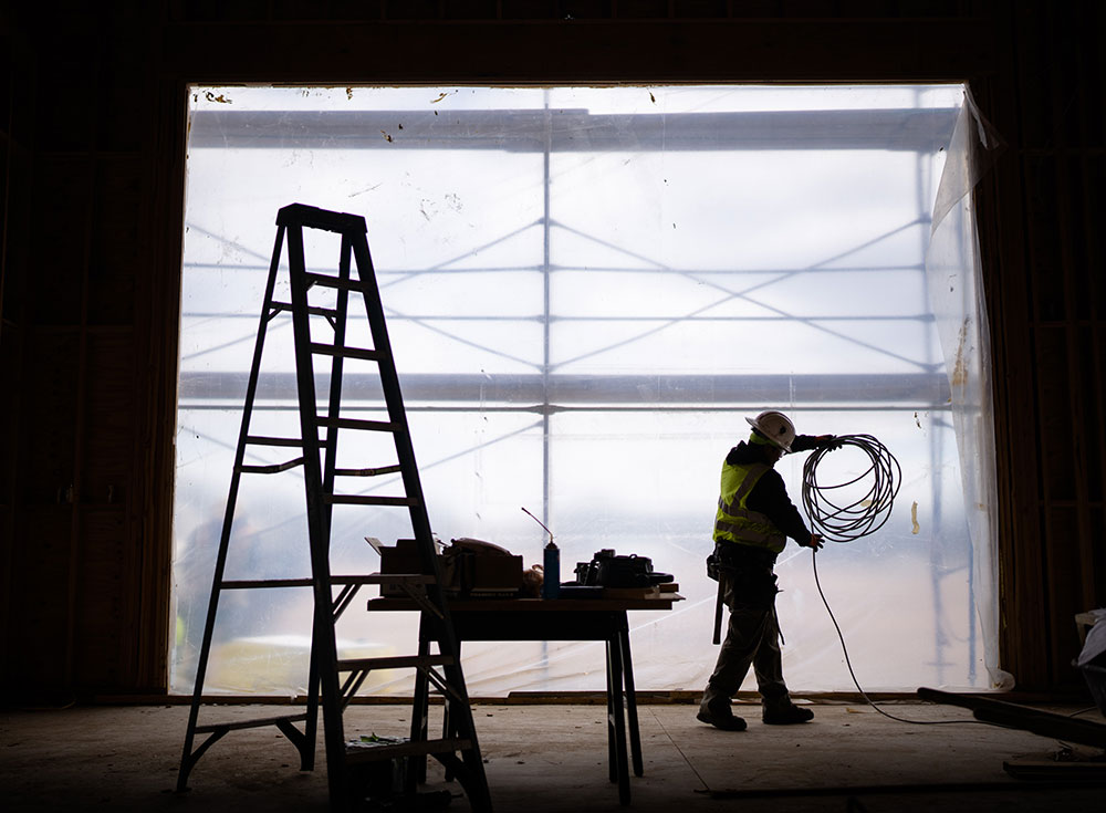 NOMINATED PROTÉGÉ — Pluma electrician Guadalupe Cardoza coils wire while working on a maintenance garage in Eldorado, New Mexico. The Sandia small-business program nominated Pluma as DOE Protégé of the Year. (Photo by Craig Fritz)