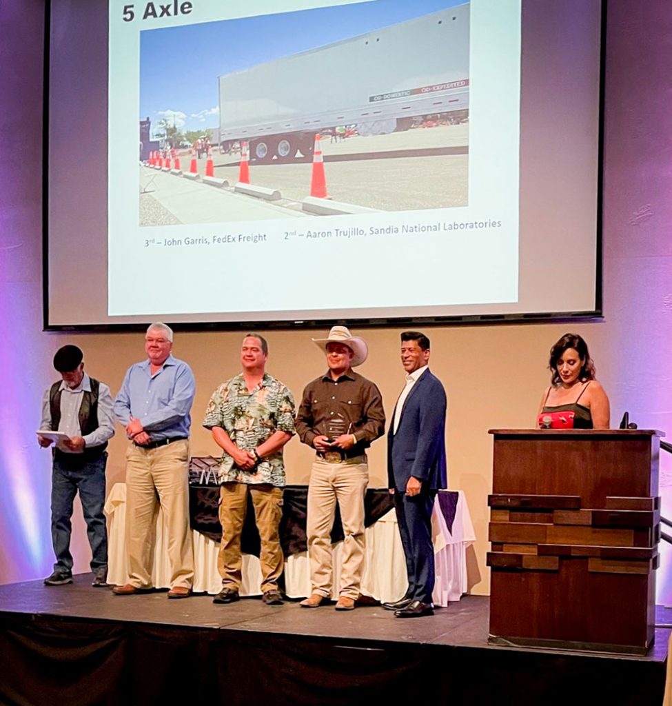 TRUCKING TITLE — Aaron Trujillo, Transportation and Receiving Heavy team member, fourth from left, was awarded second place in the Five Axle Class in the New Mexico Trucking & Safety Council 2023 Truck Driving Championship on May 20. He cited more than 10 years of experience for his success.“People can’t get in the gates and see what we’re doing daily,” Aaron said. “This win can put Sandia on the map in the trucking industry.”Aaron participated in the competition for the first time in 2022 and plans to return next year to further represent truck driving at Sandia. Sandians Dominic Torres, Luis Vergara and Bernadette Bazen also participated in the competition. (Photo by Liz Carson)