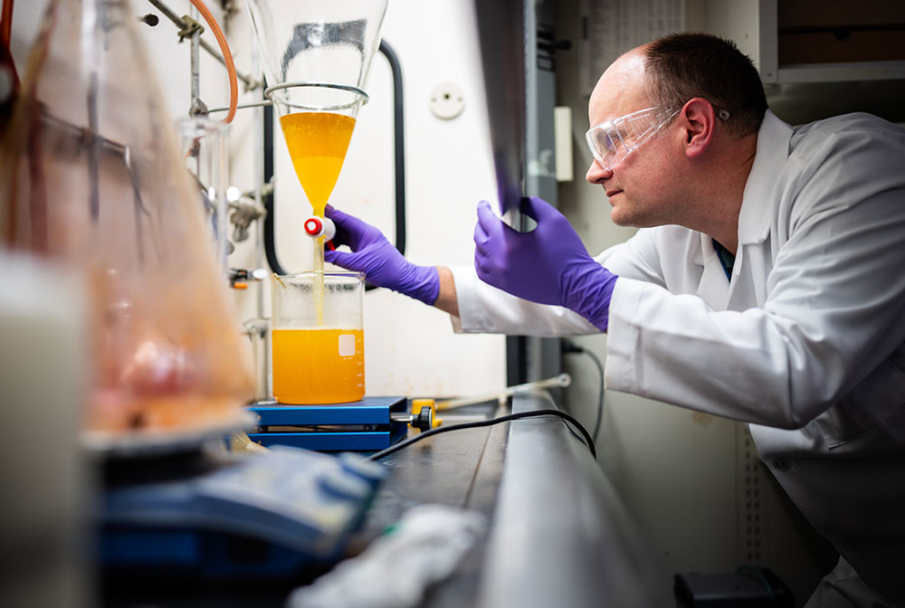 CHEMISTRY AT WORK — Sandia chemist Chad Staiger uses a separatory funnel to remove byproduct from the synthesis of a molecule. (Photo by Craig Fritz)