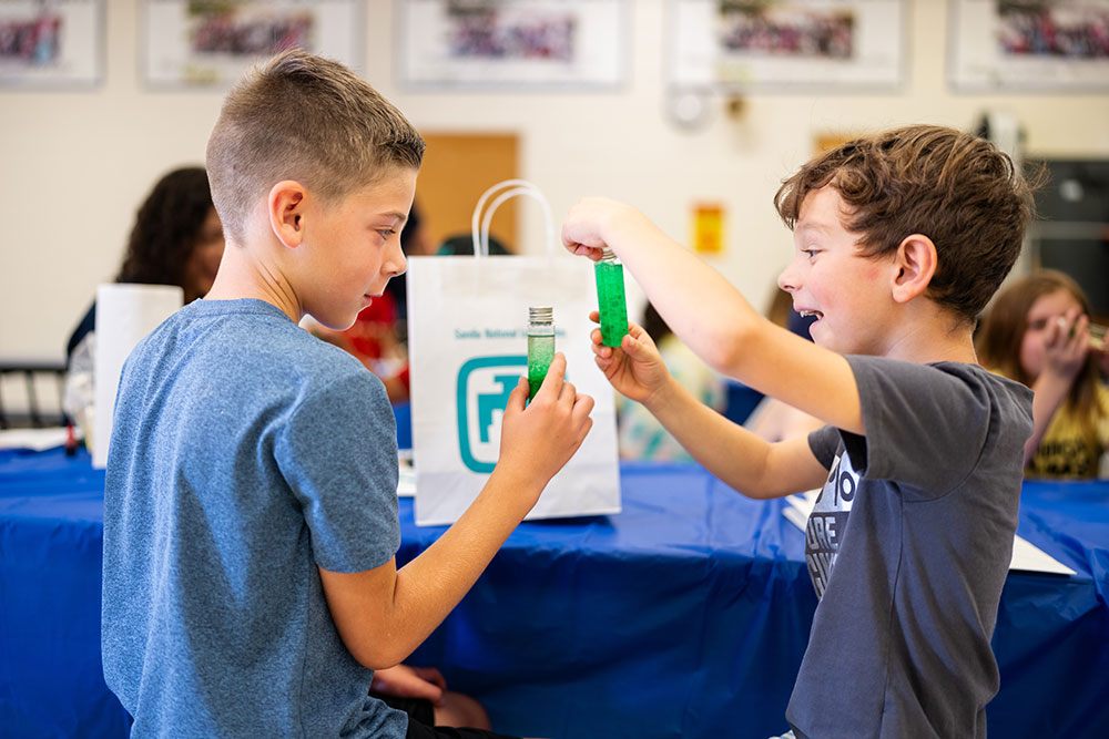 COOL CREATIONS — Quinn Fetman, 8, left, and Edward Ortega, 7, make miniature lava lamps during STEM in the Sun at Griegos Elementary School on July 26. (Photo by Craig Fritz)